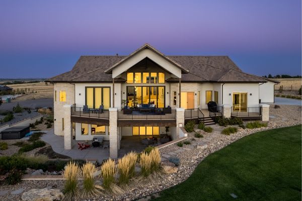 drone shot at twilight of modern house with lights on inside